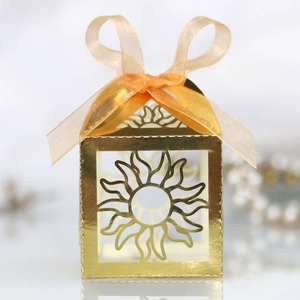 Detailed laser-cut hollow sun pattern candy box with a golden finish and ribbon bow