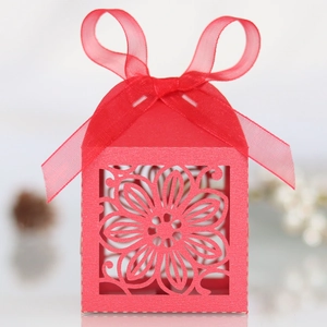 Detail van rood lasergesneden geschenkdoos met hibiscuspatroon en grote strik