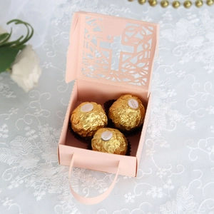 Detail of pink laser-cut cross gift box with floral patterns and pearl handles