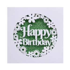 Detail of laser-cut daisy wreath and Happy Birthday text with green glitter background