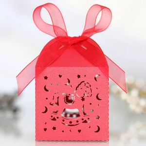 Detailed close-up of red laser-cut candy box featuring rocking horse and star patterns