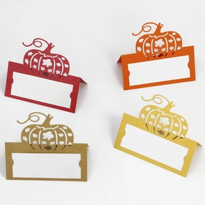 Laser-cut pumpkin place cards in autumn colors for Thanksgiving table settings