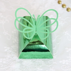 Detailed view of a 3D green laser-cut butterfly candy box on a white lace backdrop