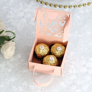 Roze lasergesneden bedankdoosje met hart en handvat gevuld met drie chocolaatjes