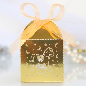 Detail of laser-cut rocking horse candy box with golden finish and orange ribbon bow