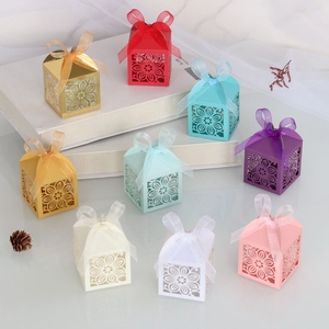 Detail van lasergesneden bruiloft snoepdoosjes in diverse kleuren met organza linten