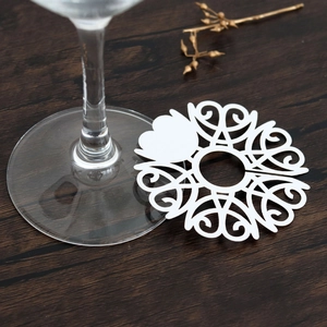 Close-up of laser-cut white heart place cards for wedding wine glass decorations