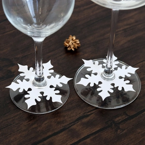 Detailed snowflake shaped white cardstock place cards for festive wine glass decoration