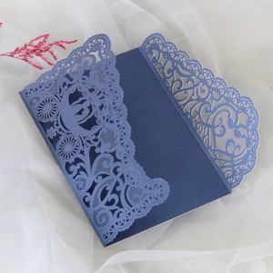 Detailed laser-cut wedding invitation featuring navy blue lace and carriage design