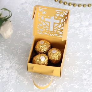 Macro detail of laser-cut cross pattern on golden gift box for wedding favors