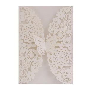 Intricate laser-cut white wedding invitation cover featuring butterfly and floral patterns