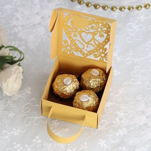 Detail van lasergesneden hartpatroon op gouden geschenkdoos met handvat voor de bruiloft