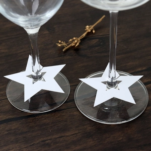 Primer plano de tarjetas blancas en forma de estrella para tallos de copas de vino
