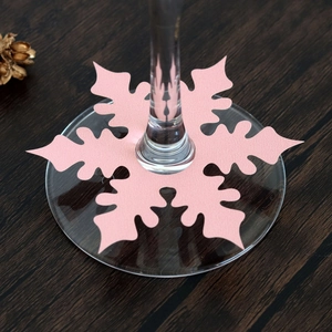 Close-up of pink snowflake wine glass place card on a festive wooden table setting