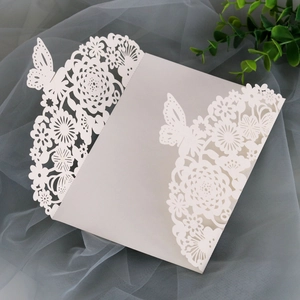 Detail of laser-cut wedding invitation featuring intricate floral and butterfly patterns