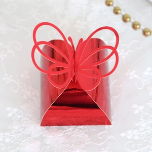 Detail showing red laser-cut hollow butterfly design on a shiny metallic gift box