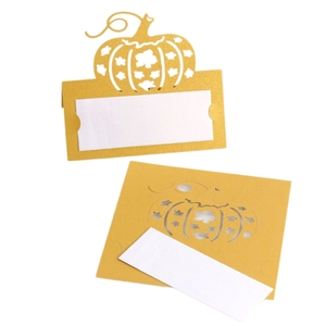 Golden laser-cut pumpkin place cards with white inserts for festive table settings