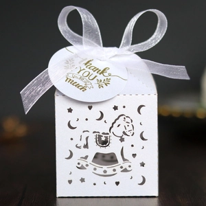 Detail of white laser-cut rocking horse candy box with ribbon and Thank You tag