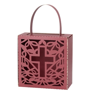 Macro detail of wine red gift box featuring laser-cut hollow cross and vine patterns