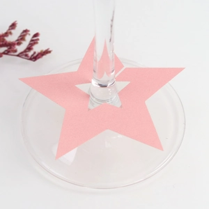 Primer plano de marcadores de copas de papel rosa en forma de estrella para fiestas