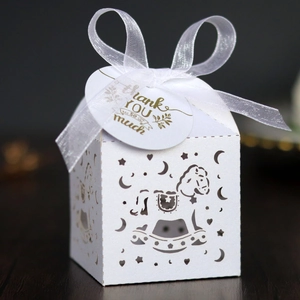 Detail of laser-cut gift box with rocking horse motifs and 'Thank You' gold tag