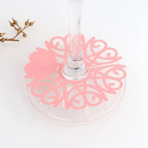 Detail of pink laser-cut heart paper wine glass base cards for wedding table decor