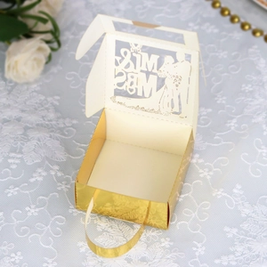 Détail macro d'une boîte de mariage découpée au laser MR & MRS avec dorure et carton ivoire