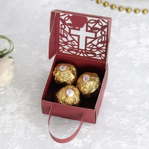 Detail of wine red hollow cross favor box with laser-cut patterns and elegant handle