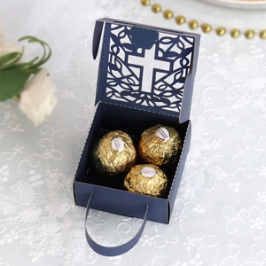 Detail of navy blue hollow cross candy box with laser-cut patterns and silk handle