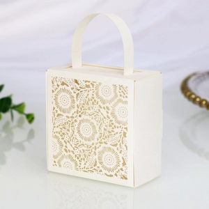 Detail showing the intricate laser-cut floral lace pattern on white wedding favor box