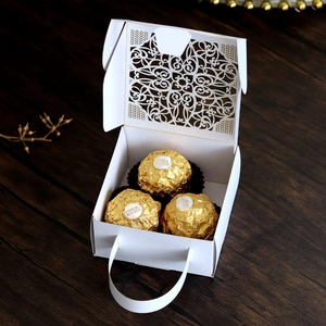 Detail view of white lace hollow candy box with portable handle for wedding favors