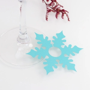 Detail of light blue snowflake wine glass card with center hole for wedding place settings