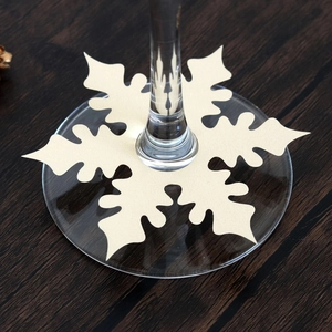 Close-up of snowflake-shaped paper place card on a wine glass base for Christmas table