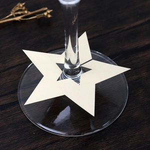 Primer plano de tarjetas de mesa con forma de estrella para copas de vino tinto