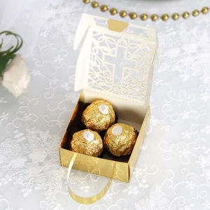 Detail of laser-cut cross gift box with gold handle and hollow vine patterns