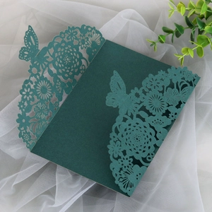 Detail of laser-cut butterfly floral wedding invitation cover in elegant dark green