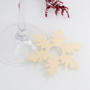 Close-up of champagne gold snowflake wine glass name cards made of pearlescent paper