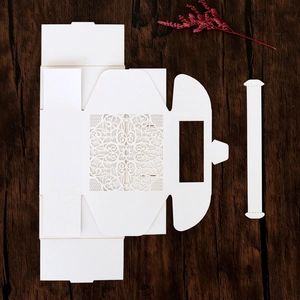 Macro view of white laser-cut hollow lace wedding candy box with intricate floral patterns