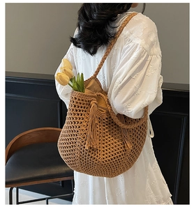Détail du sac hobo en paille tissé à la main avec franges et texture en maille marron