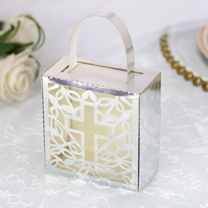 Detail of silver laser-cut wedding favor box with hollow cross and floral pattern