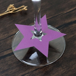 Detalle macro de la tarjeta de lugar morada en forma de estrella para copa de vino