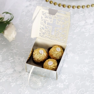 Close-up of laser-cut cross hollow gift box with elegant vine pattern for wedding favors