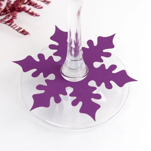 Detailed view of a purple snowflake place card on a wine glass stem for Christmas