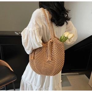 Détail du sac cabas tissé kaki avec motif en maille ajourée et pompon décoratif chic