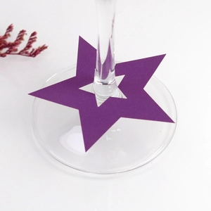 Primer plano de una tarjeta de papel morada en forma de estrella para copa de vino