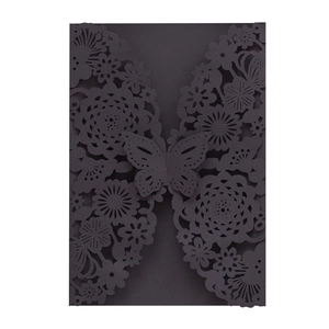 Detail of laser-cut black floral invitation cover with butterfly closure detail