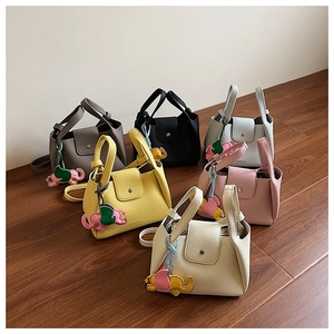 Top view of compact pebbled leather bucket bags in six vibrant colors with charms