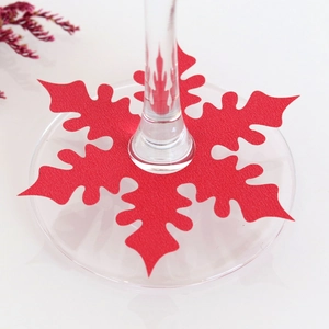 Close-up of red snowflake felt place cards on wine glass stems for Christmas table setting