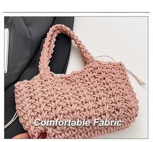 Detail der rosa Strickhandtasche mit strukturierter Baumwollwebung und cremefarbenem Zugband