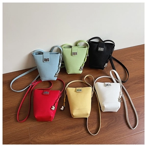 Group shot of colorful minimalist bucket bags featuring metal heart pendants and twist locks